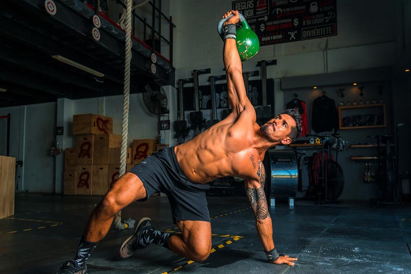 man working out with kettle bells
