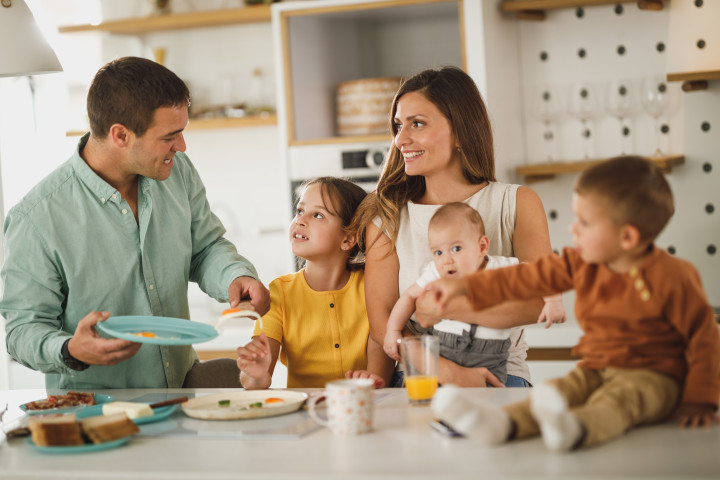 mother and father with small children in the kitchen